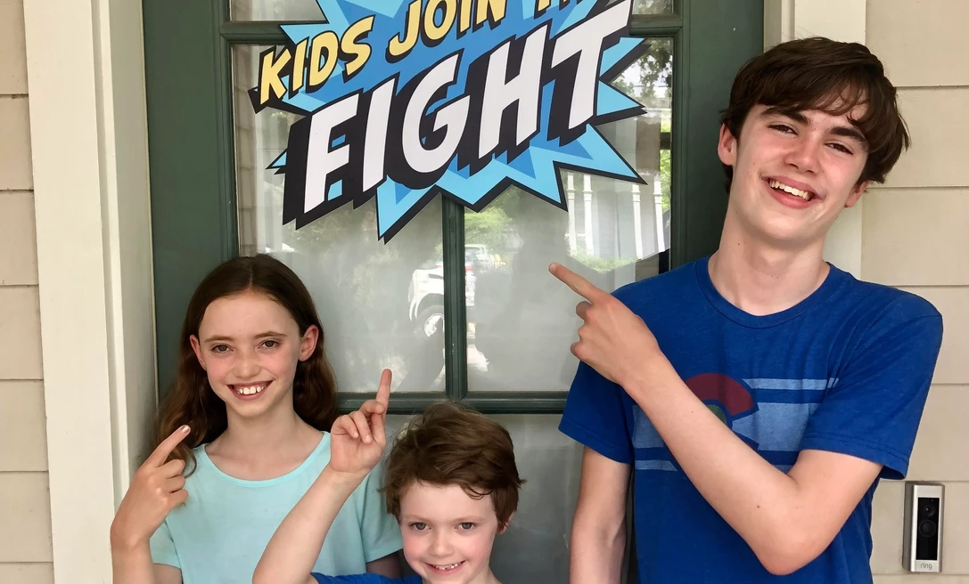 kids in front of kjtf logo on door